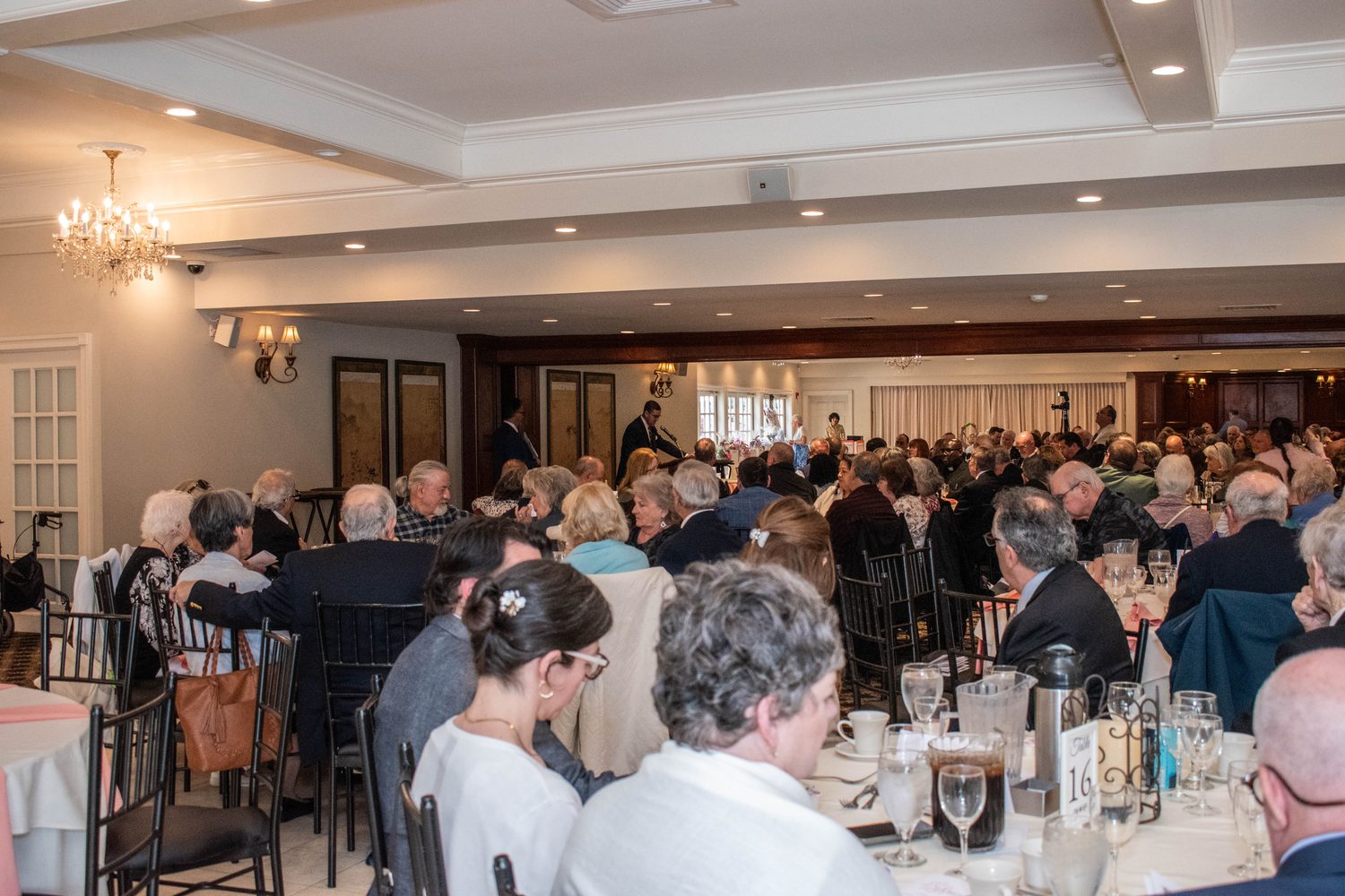 A full banquet room of guests seated at round tables during the dinner